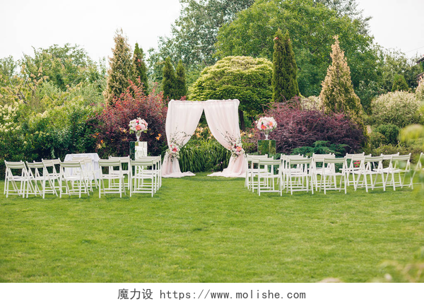 户外草坪上的婚礼布置拱和婚礼上的椅子上